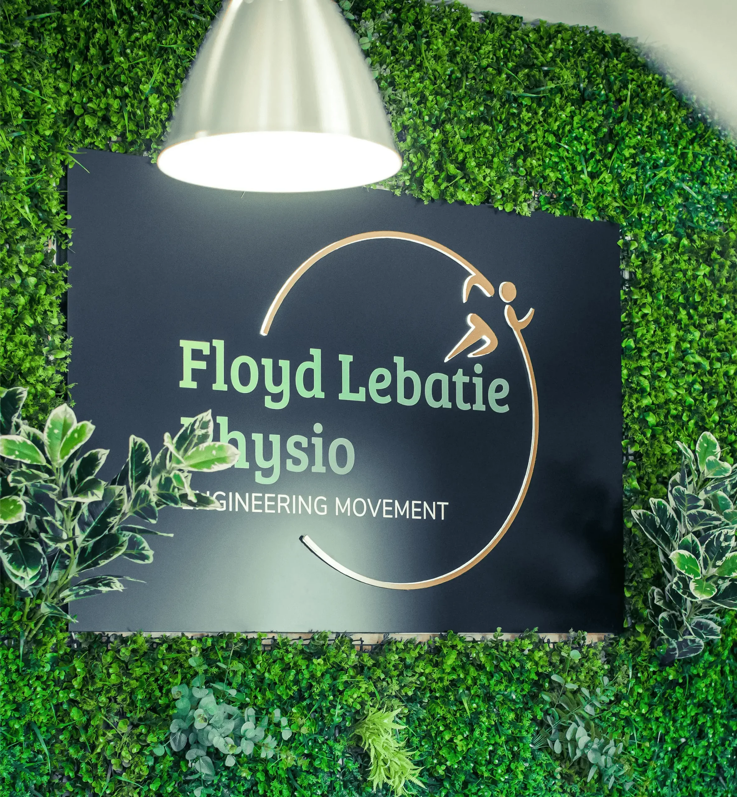 Floyd Lebatie Physiotherapy signage displayed on green leaf wall inside Midrand clinic