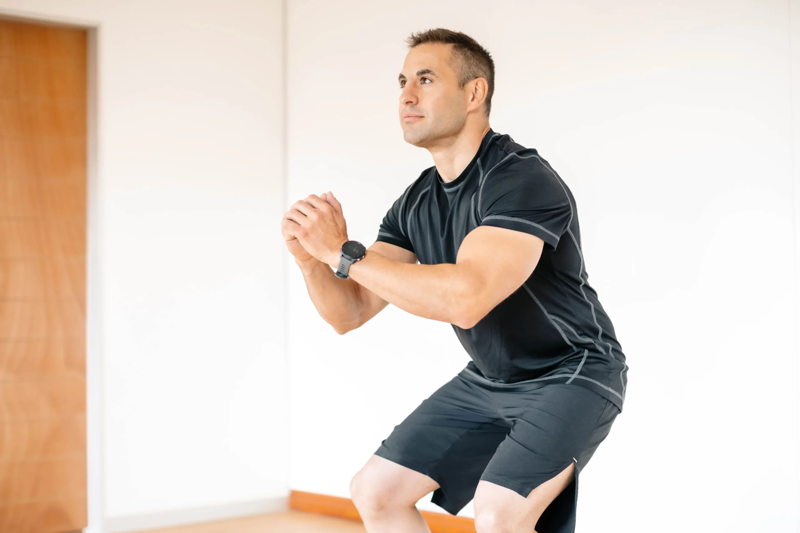 Male patient performing deep squat mobility exercise as part of executive rehabilitation programme