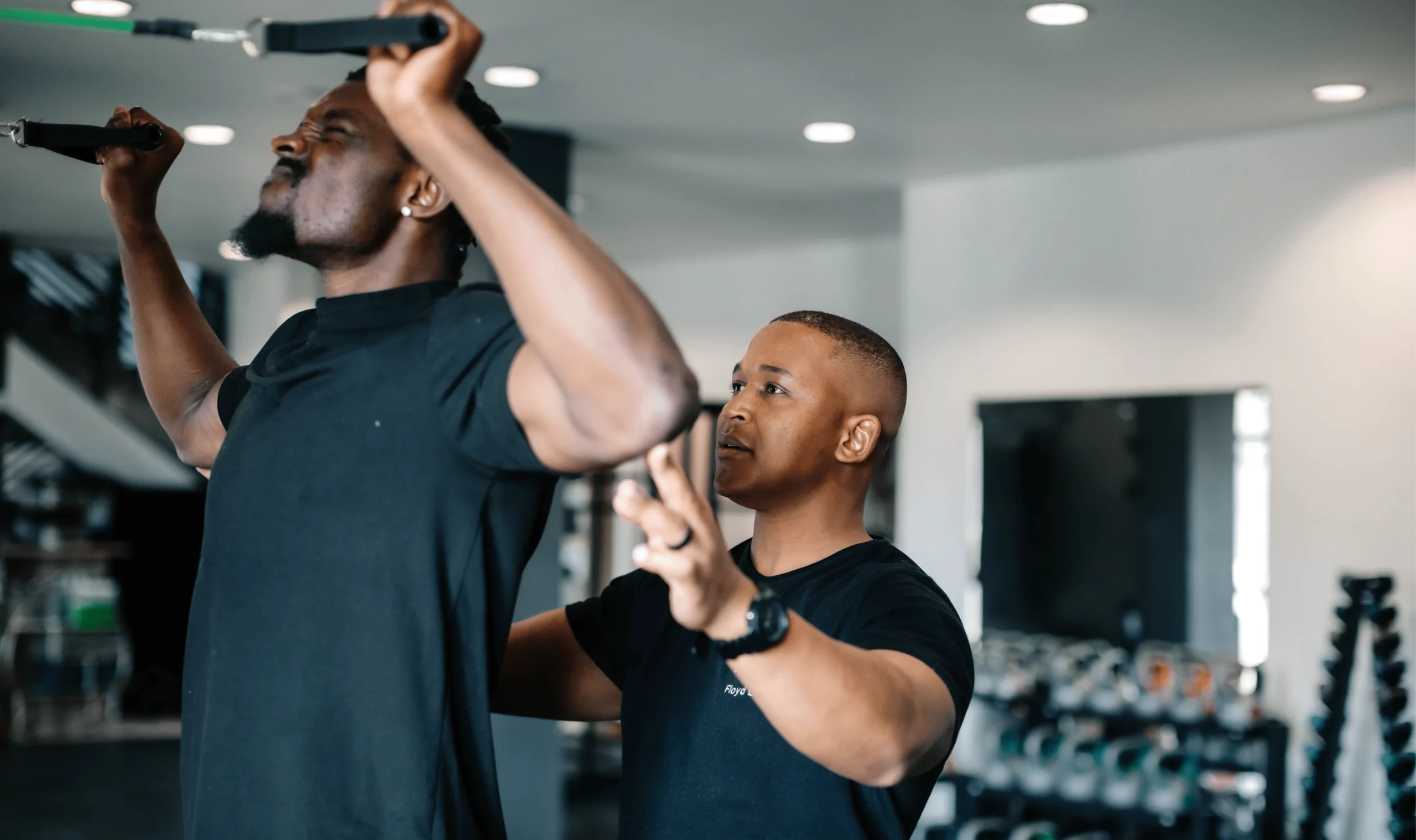 Sports physiotherapist assisting athlete with resistance band upper body stretch